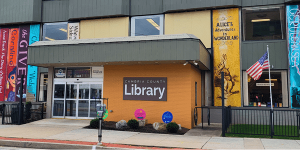 Beaverdale library has a red roof, door, and black shutters.
