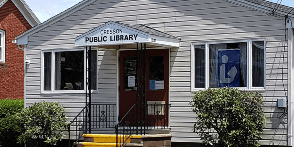 Beaverdale library has a red roof, door, and black shutters.