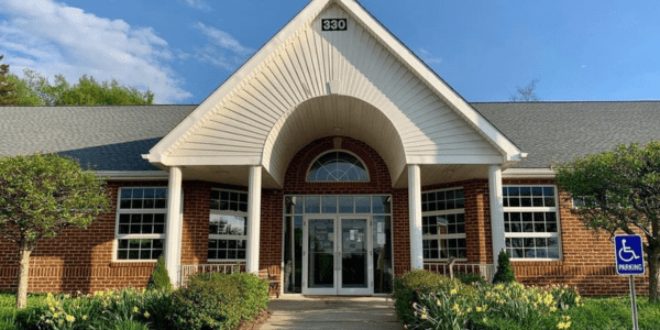 Beaverdale library has a red roof, door, and black shutters.