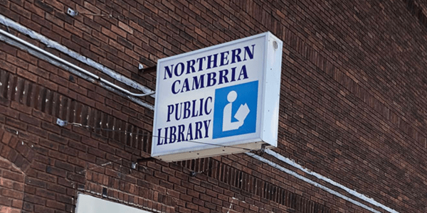 Beaverdale library has a red roof, door, and black shutters.