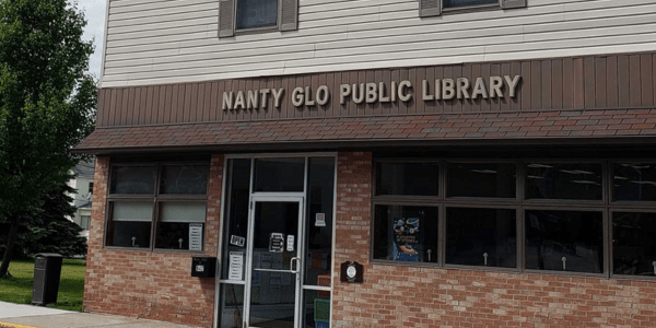 Beaverdale library has a red roof, door, and black shutters.